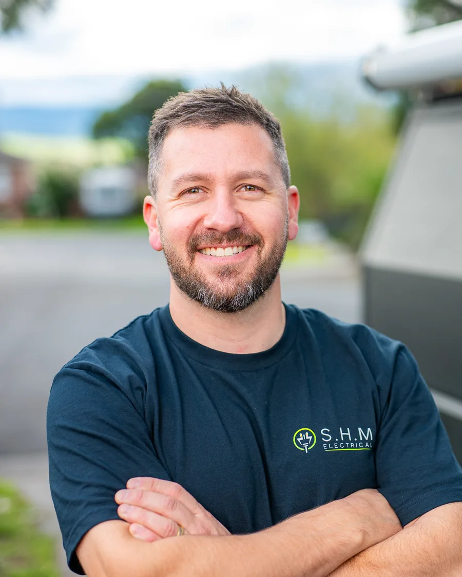 Anthony, licensed electrician and owner of S.H.M Electrical, standing in front of his work ute