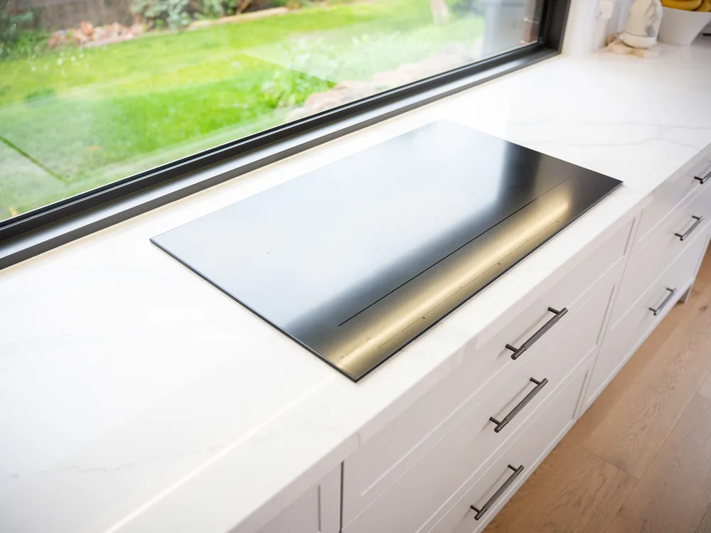 Induction cooktop installed flush into a stone kitchen benchtop